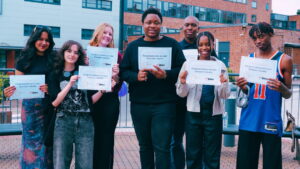 7 students holding results certificates outside the A Level Centre at Sutton Coldfield College