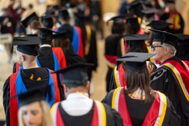 Students in graduation dress walking in procession