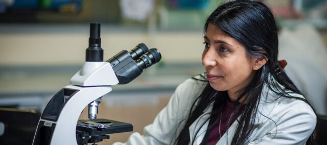 Student looking through microscope
