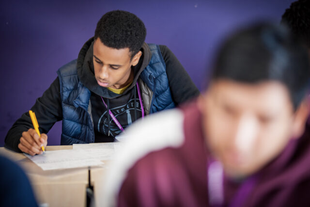 Student writing in classroom
