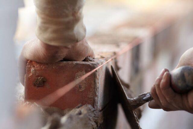 Hands laying bricks