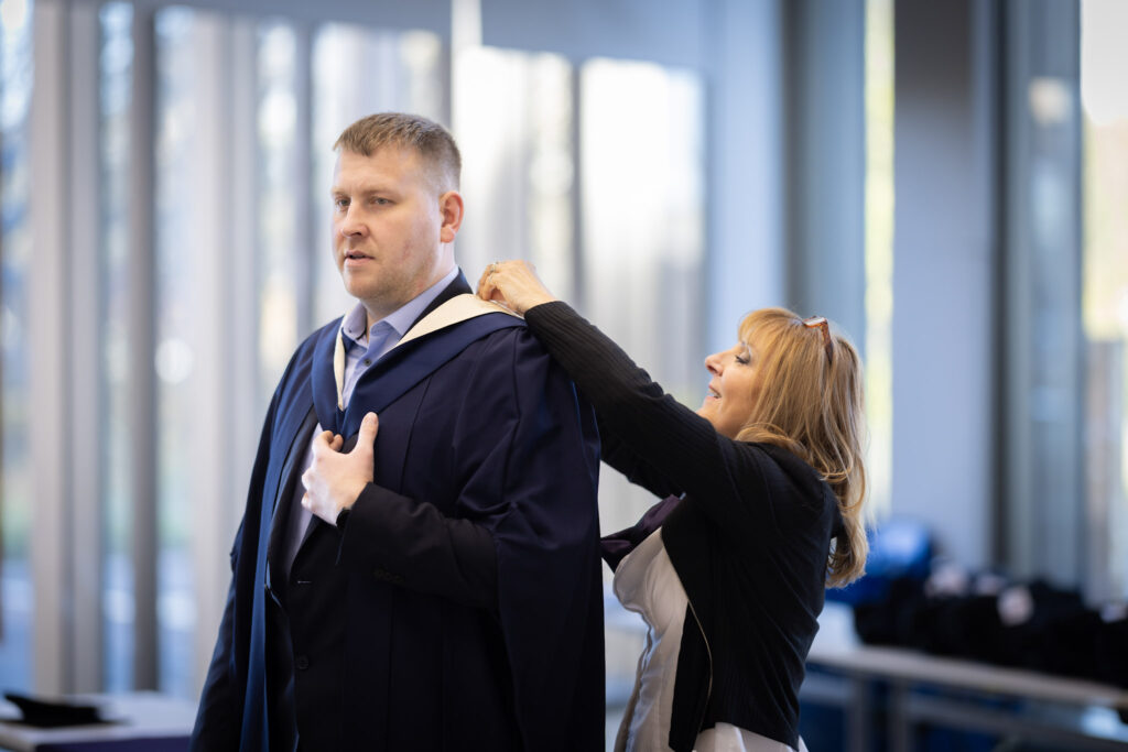 Davis putting on his graduation gown.