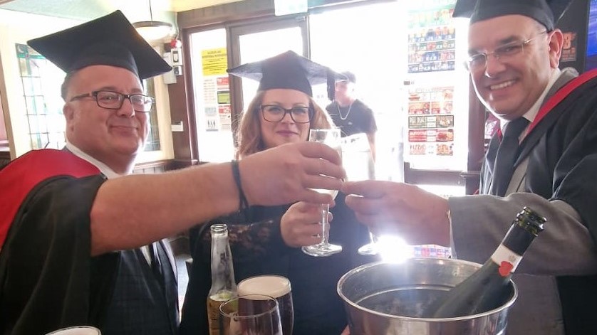 Three teachers toasting to their graduation