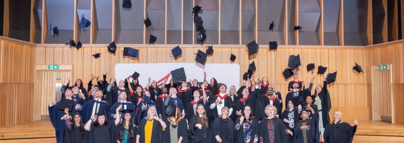 HE Graduates throwing hats