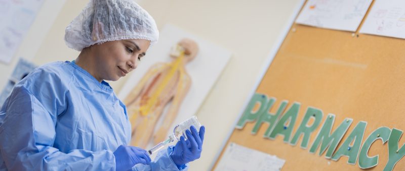 Pharmacy student filling a syringe