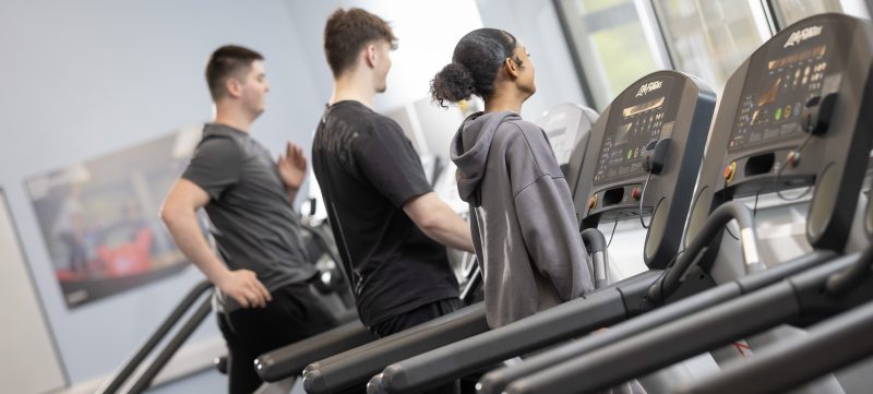 Three students running on a treadmill