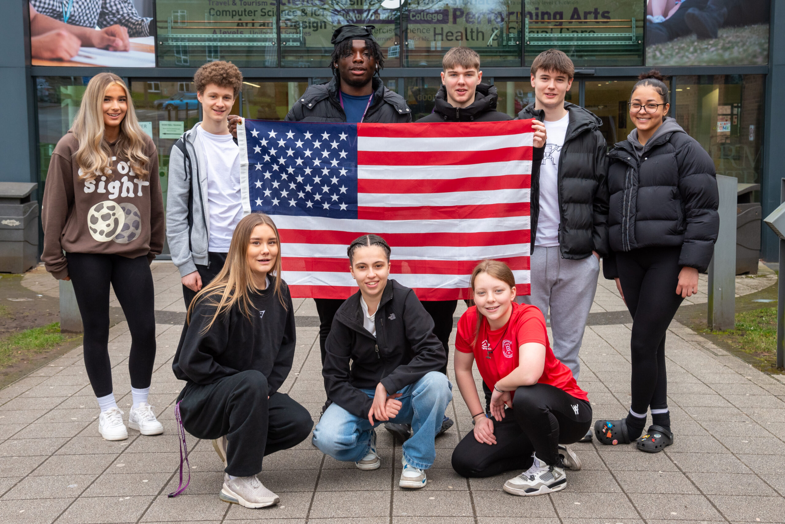BMet sports science students holding up a USA flag outside Sutton Coldfield College