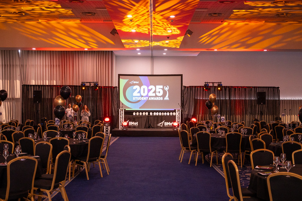 Edgbaston Cricket Stadium conference hall with chairs, tables and stage with screen.