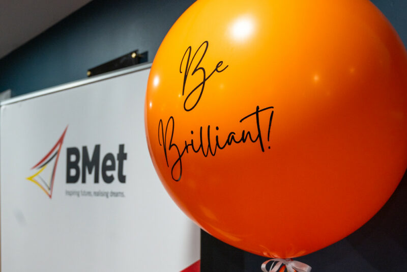 Orange balloon featuring the words 'Be Brilliant'